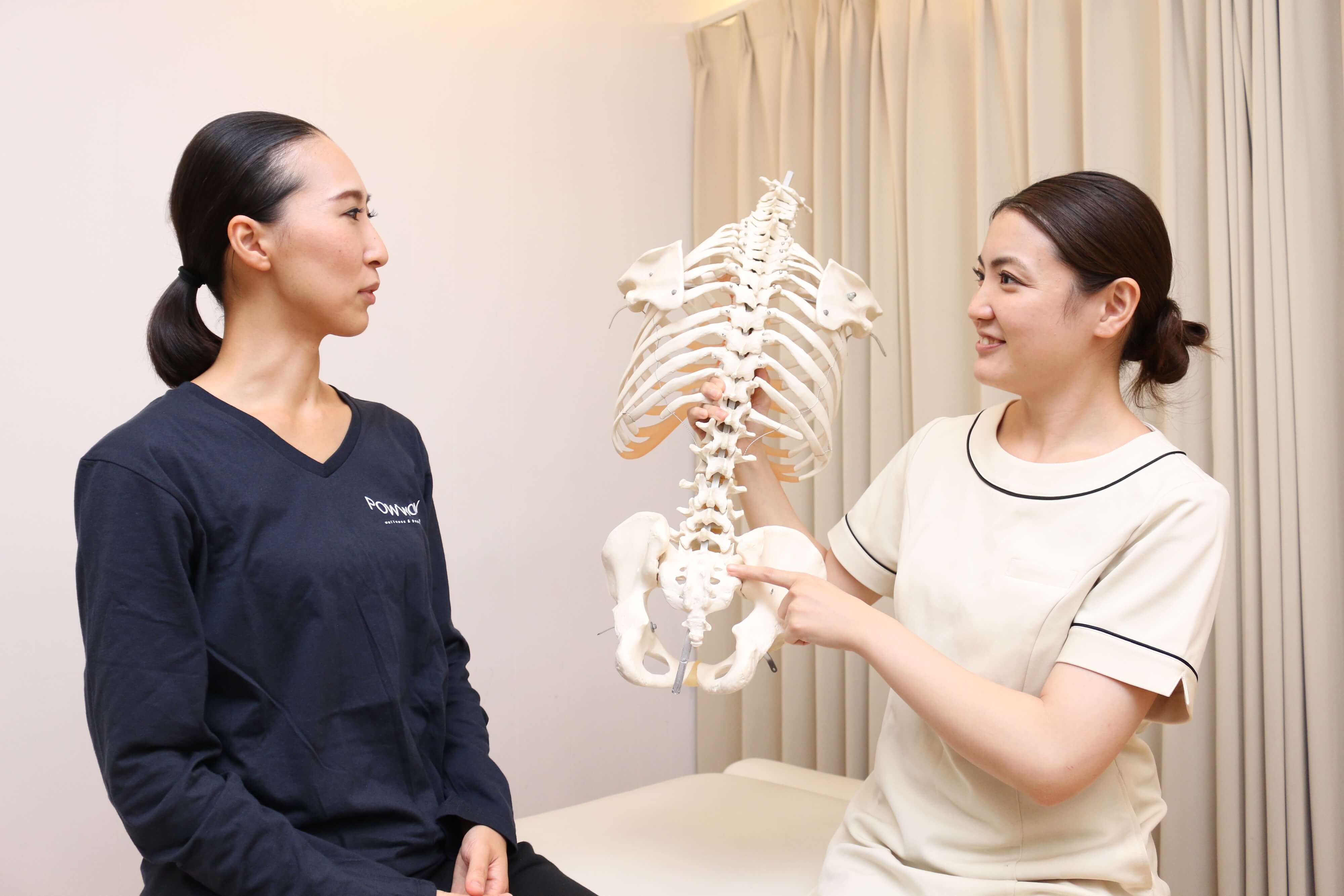 写真：骨の模型をつかって仙骨の説明をしている